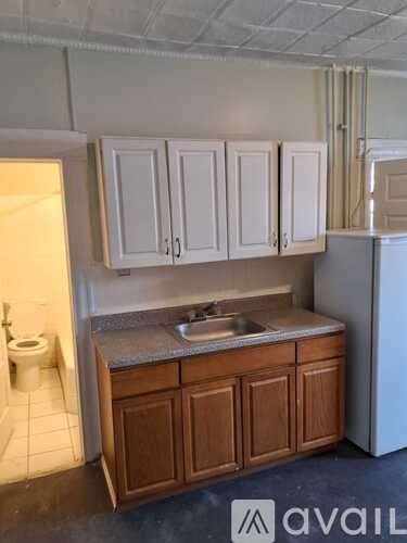 A kitchen with white cabinets and a wooden counter.