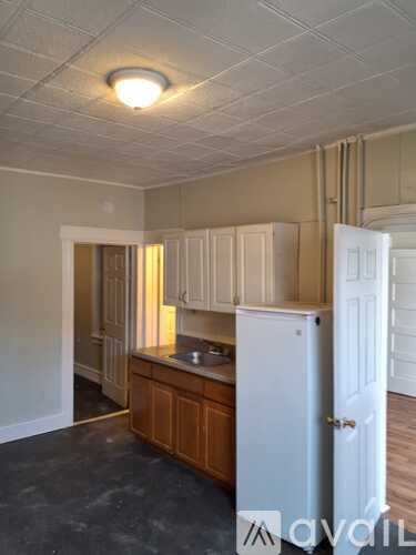 A kitchen with white cabinets and a white refrigerator.