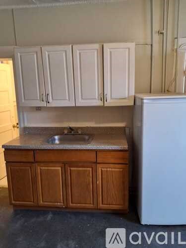 A kitchen with white cabinets and a wooden counter.