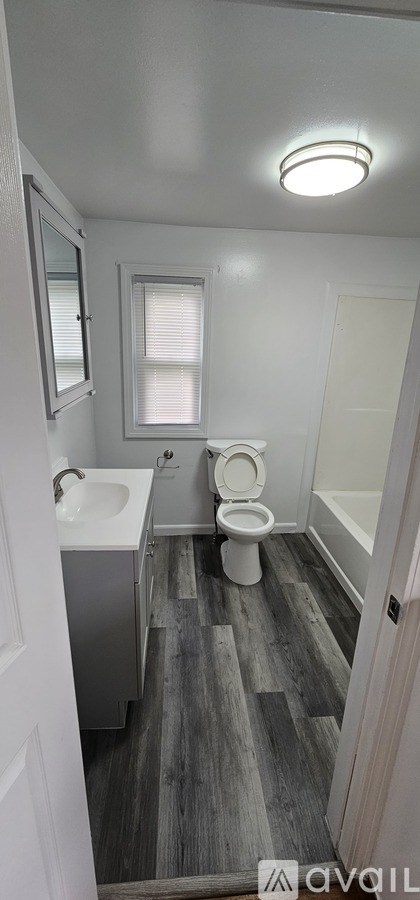 A bathroom with a toilet, sink, and bathtub.