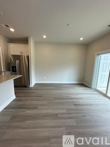 A kitchen area with a refrigerator and cabinets.