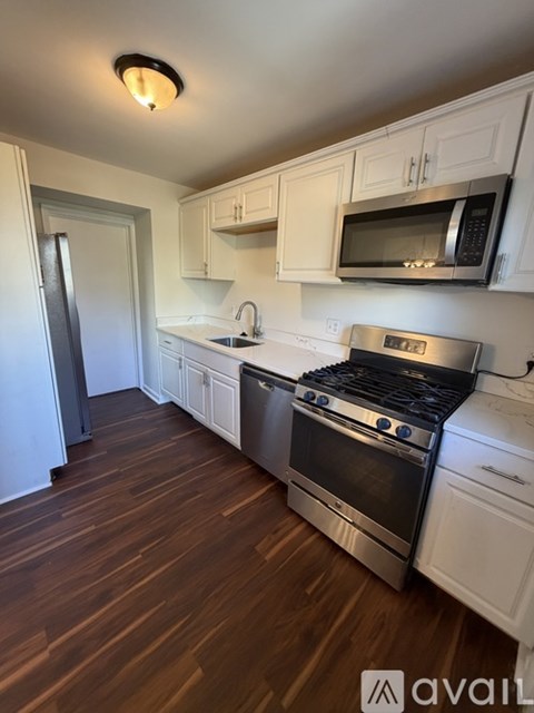 A kitchen with white cabinets and a stainless steel oven.