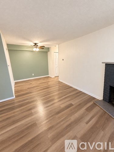A room with a fireplace and wood flooring.