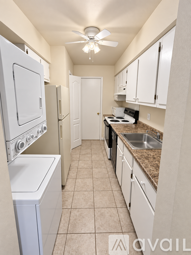 A kitchen with white appliances and cabinets.