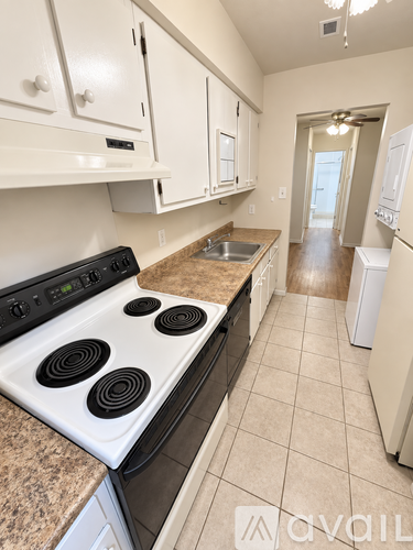 A kitchen with a stove top oven and a refrigerator.