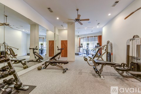 A gym with a variety of exercise equipment including treadmills, stationary bikes, and weight machines.