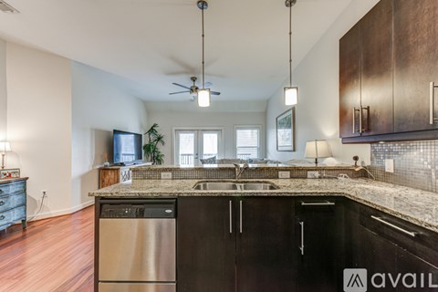 A kitchen with dark wood cabinets and a granite countertop.