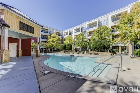 A swimming pool in a residential area surrounded by trees and buildings.