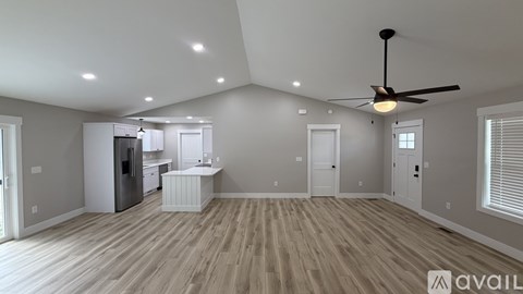 A spacious room with a ceiling fan and wooden flooring.