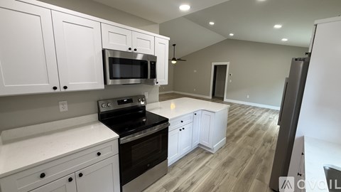 A kitchen with white cabinets and a black stove top oven.