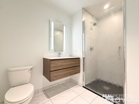 A bathroom with a toilet, sink, and shower.