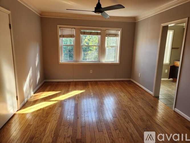 A room with wooden flooring and a ceiling fan.