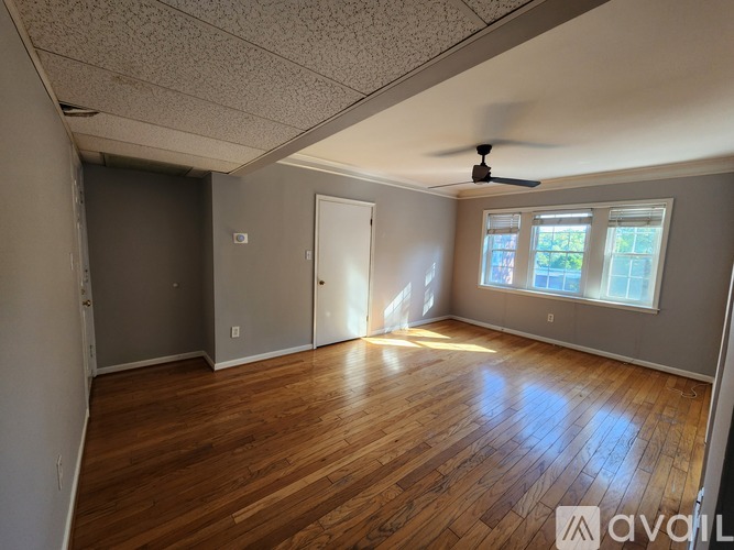 A room with wooden floors and a ceiling fan.