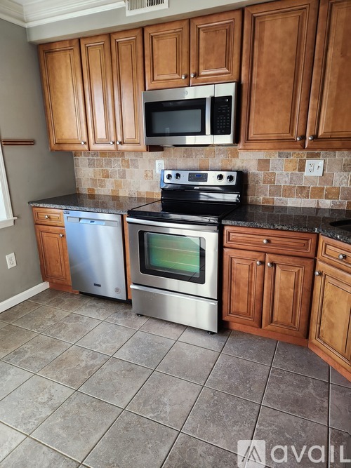 A kitchen with wooden cabinets and a black stove top oven.