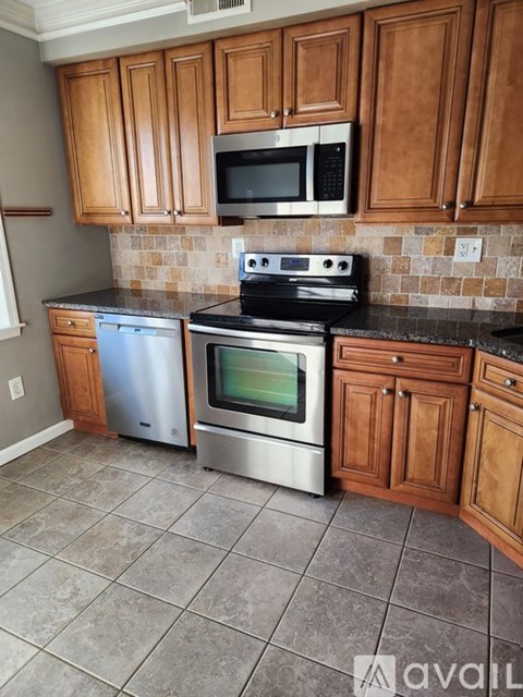 A kitchen with wooden cabinets and a black stove top oven.