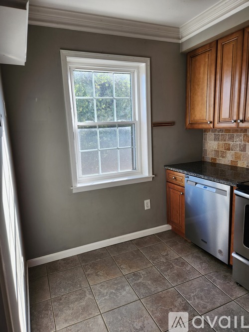 A kitchen with a window and a dishwasher.
