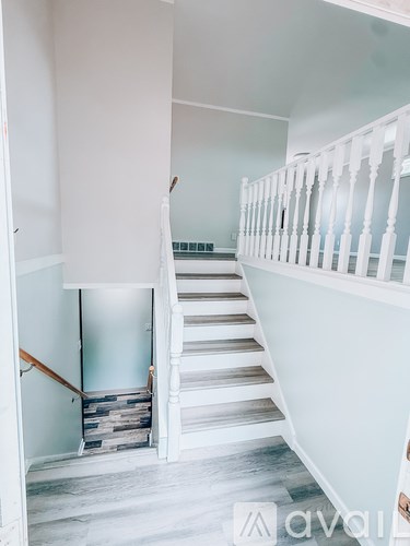 A staircase with a white railing and wooden steps.