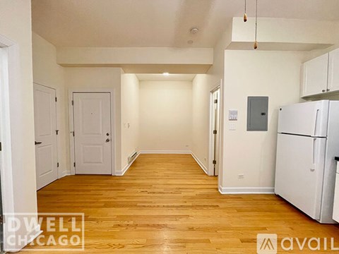 A spacious room with wooden floors and white walls.