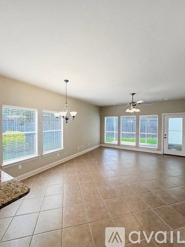 A spacious room with tiled flooring and a ceiling fan.