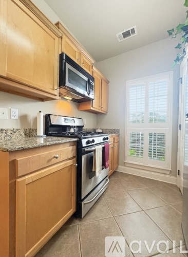 A kitchen with wooden cabinets and a stove top oven.