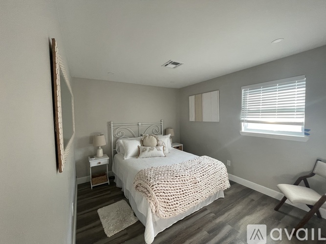 A bedroom with a large bed and a chair.