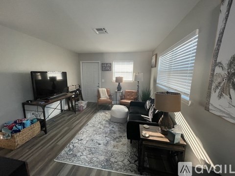 A living room with a flat screen TV and a rug.