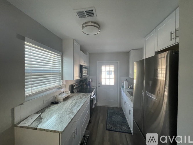 A kitchen with a refrigerator, stove, and sink.