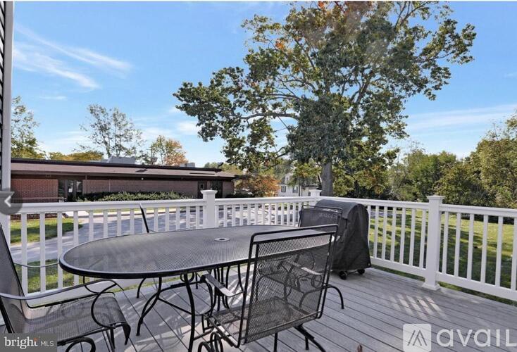A patio with a table and chairs is set up on a deck.