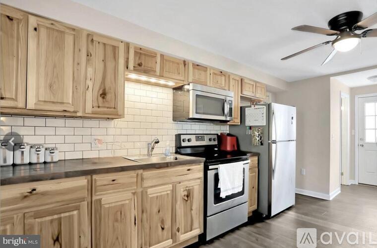 A kitchen with wooden cabinets and a white refrigerator.