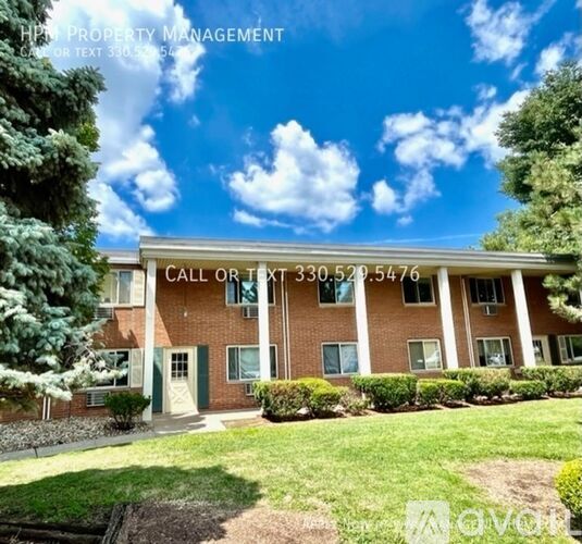 A building with a sign that says "Call or Text 330.520.5476" is surrounded by greenery.
