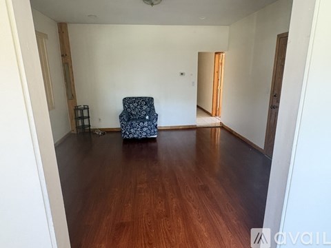 A room with wooden floors and a blue chair.