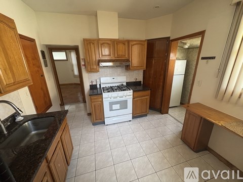 A kitchen with wooden cabinets and a white stove top oven.