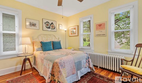 A bedroom with a bed, a chair, and pictures on the wall.