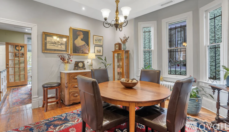 A dining room with a wooden table surrounded by chairs.