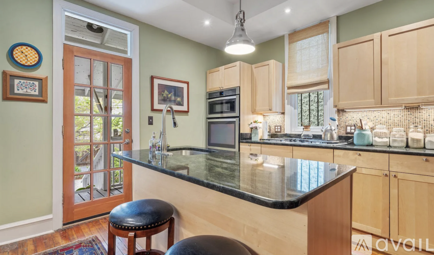 A kitchen with a black counter top and wooden cabinets.