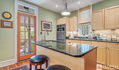 A kitchen with a black counter top and wooden cabinets.