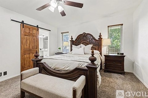 A bedroom with a large bed and a ceiling fan.