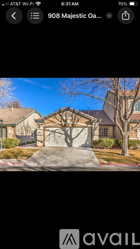 A house with a driveway and a tree in front of it.