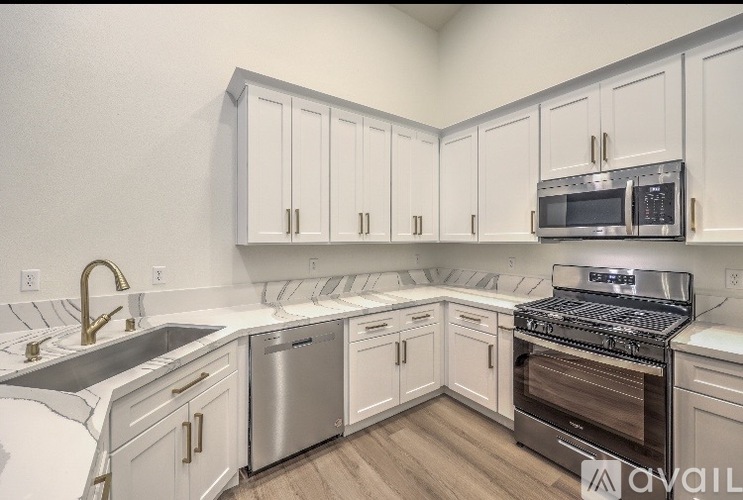 A kitchen with white cabinets and stainless steel appliances.