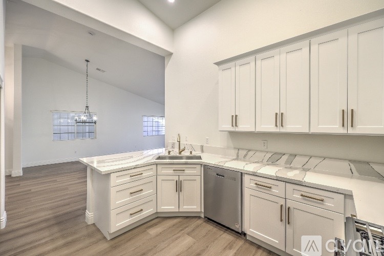 A modern kitchen with white cabinets and stainless steel appliances.