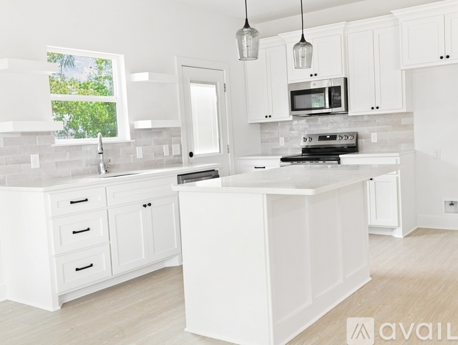 A kitchen with white cabinets and a black stove top oven.