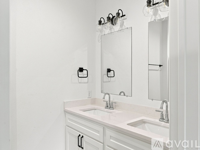 A white bathroom with a sink and mirror.