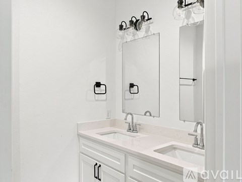 A white bathroom with a sink and mirror.