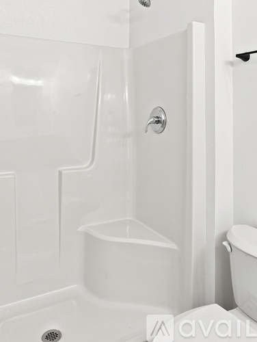 A white bathroom with a tub and toilet.