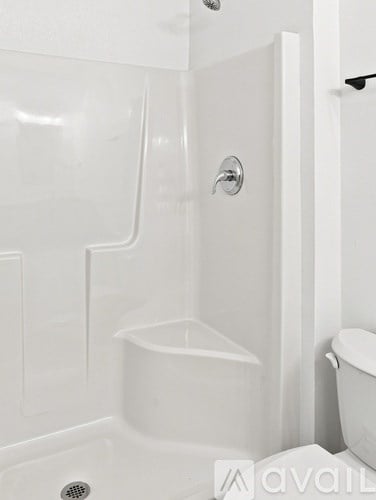 A white bathroom with a tub and toilet.