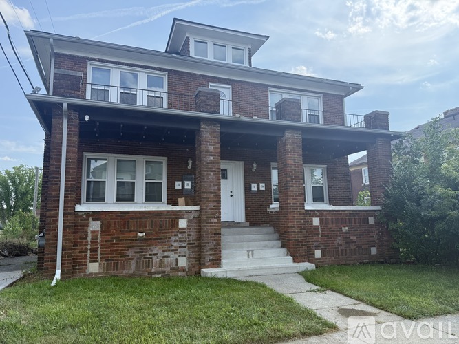 A two-story brick house with a white door and windows.