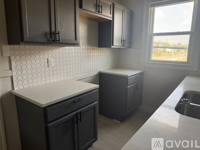 A kitchen with black cabinets and a white countertop.