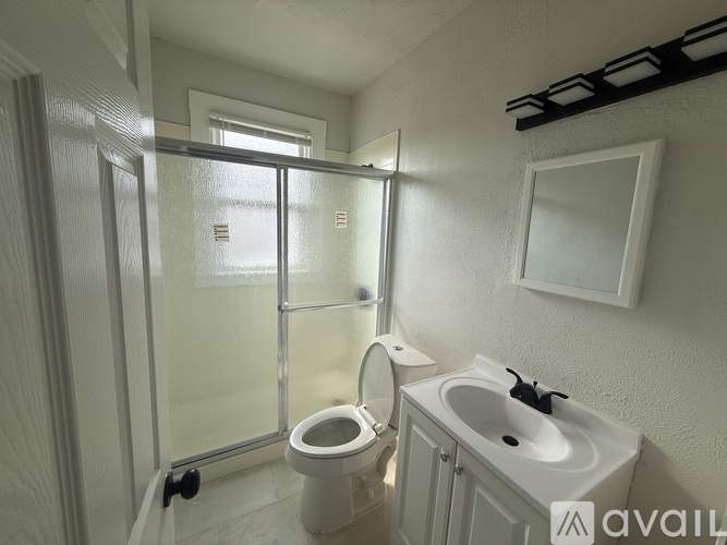 A bathroom with a toilet, sink, and shower.