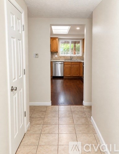 A kitchen area with a dishwasher and wooden cabinets.