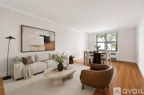 A living room with a white couch, a brown armchair, and a coffee table.